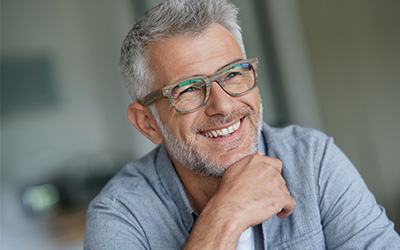 Man with glasses smiling.